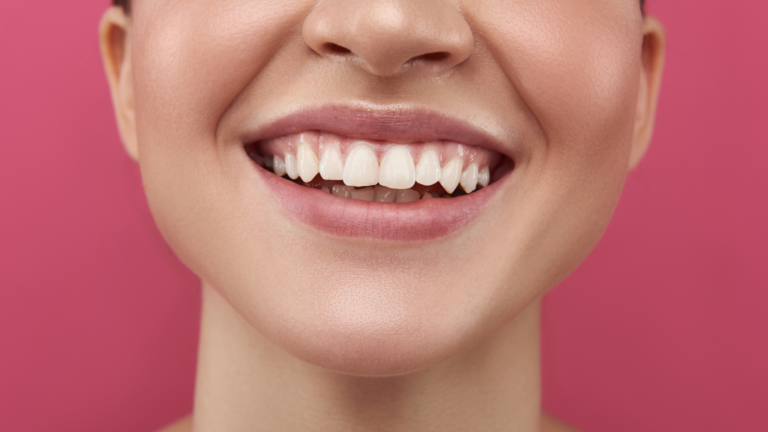 una primo piano di donna che sorride su sfondo rosa. rappresenta la fiera INNOVATIONBEAUTY LAB, la fiera delle connessioni.
