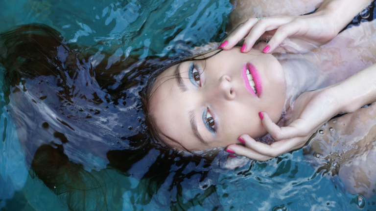in foto una donna truccata immersa nell'acqua, rappresenta il tema dell'articolo, il trucco waterproof.