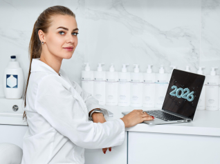 Estetista professionista in ambiente professionale e moderno, utilizza un laptop con la scritta 2026, circondata da prodotti skincare professionali: immagine simbolo della nuova estetica professionale orientata a competenza, tecnologia e visione futura.