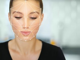 Un volto di una donna su sfondo grigio con dei disegni geometrici sul viso: il futuro secondo la fiera Innovation Beauty Lab