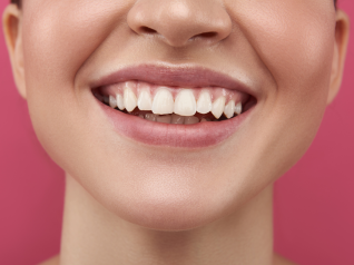 una primo piano di donna che sorride su sfondo rosa. rappresenta la fiera INNOVATIONBEAUTY LAB, la fiera delle connessioni.